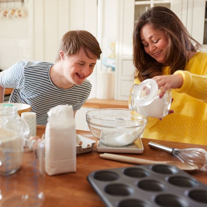 woman teaching disabled child how to bake