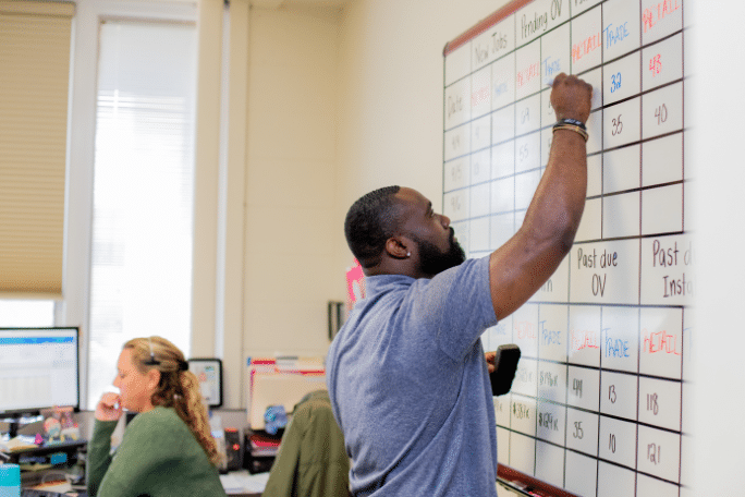 man organizing data on whiteboard