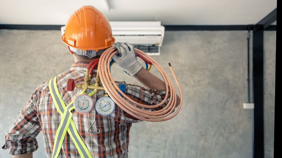 HVAC technician in front of AC