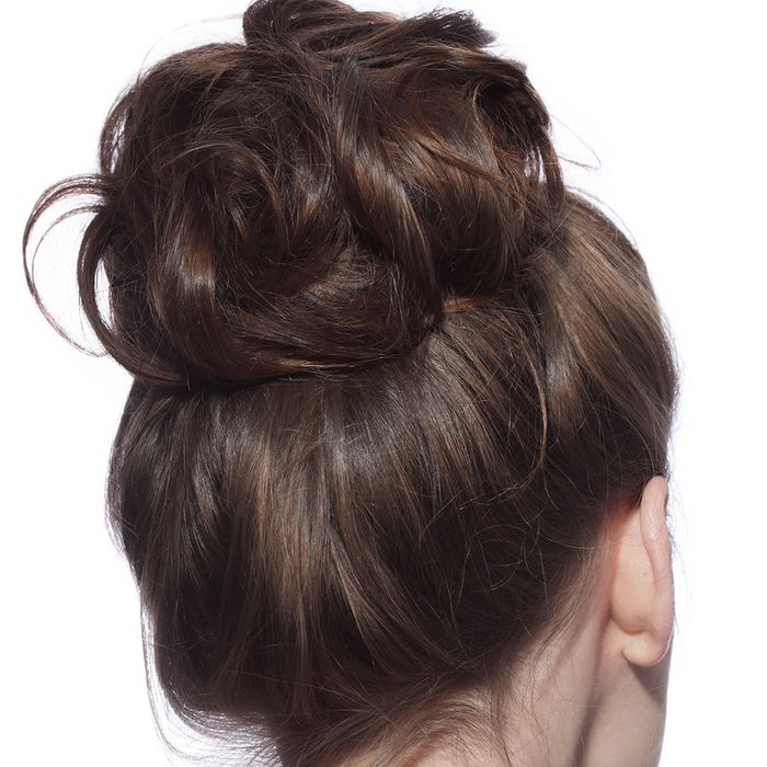 Back of brunette woman’s head with a large, loose bun in her hair.