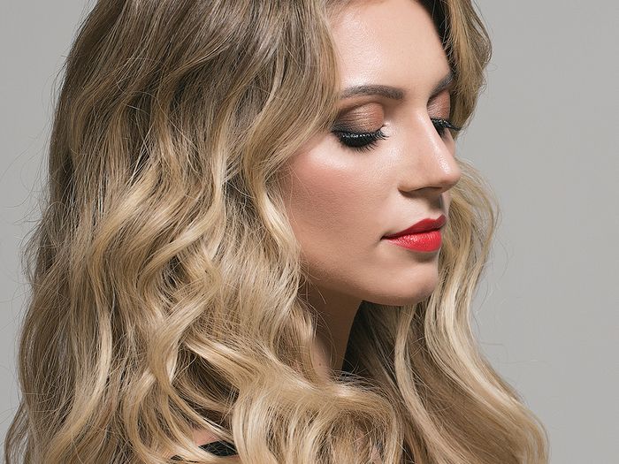 Profile view of woman with long, blonde wavy hair.