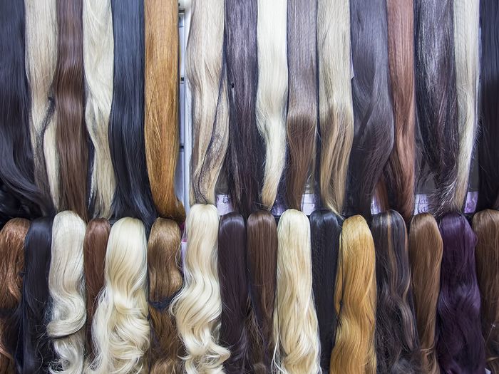 Different colors of hair extensions in a wig store.