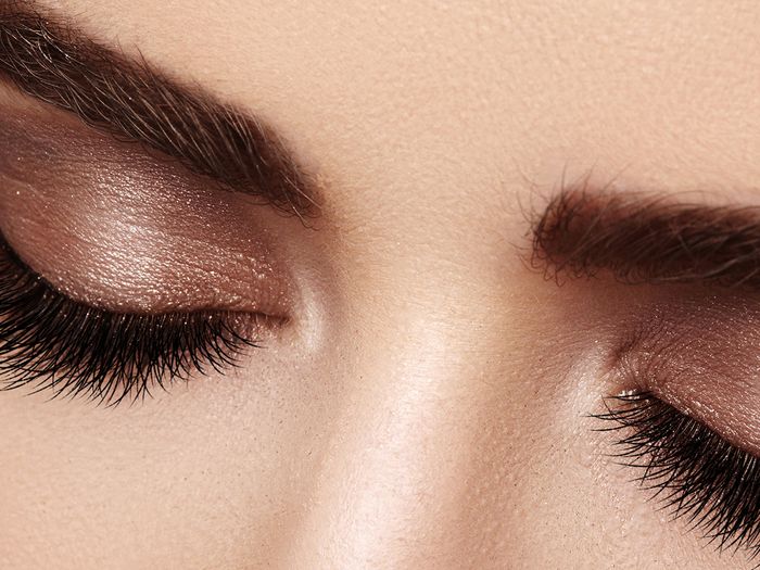 Close up of a woman’s closed eyes showing her eyeshadow and long eyelashes.