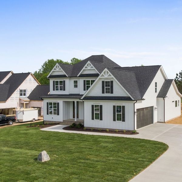 Large white farmhouse-style home with a newly installed black asphalt shingle roof and matching black shutters