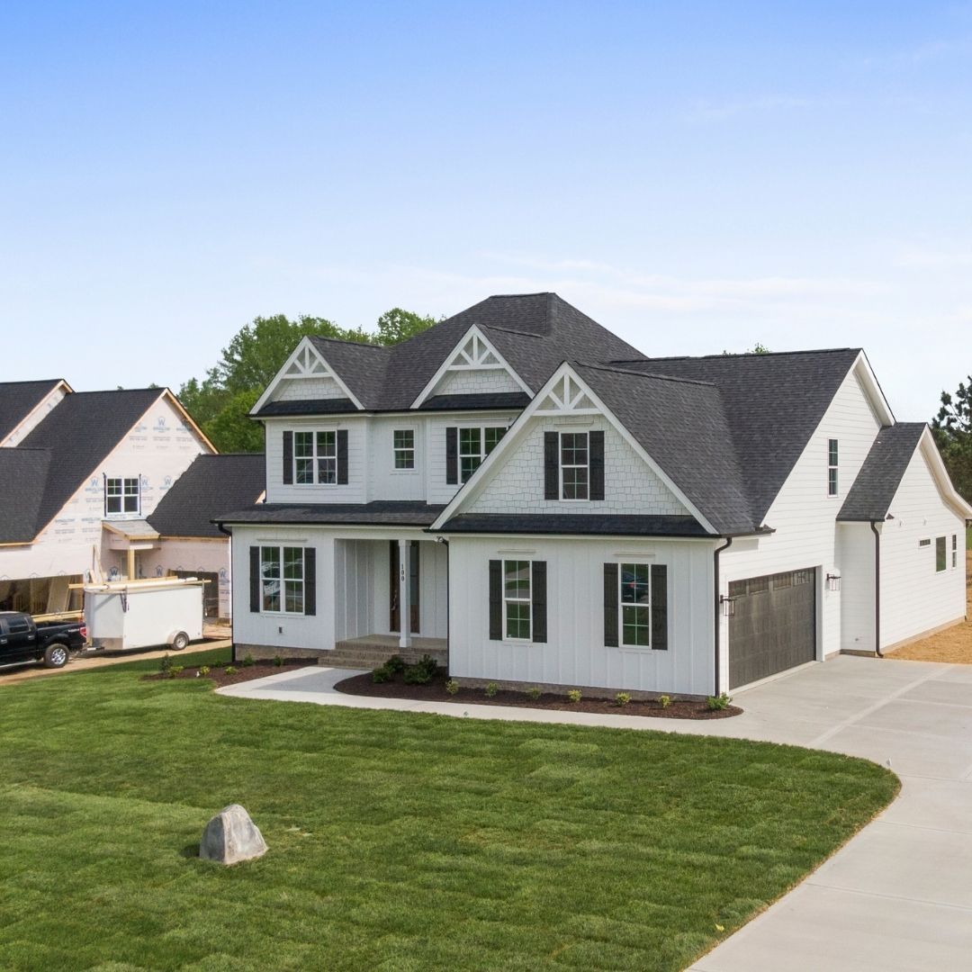 Large white farmhouse-style home with a newly installed black asphalt shingle roof and matching black shutters