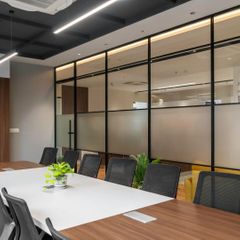 Professional commercial office renovation featuring a modern conference room with glass partition walls and industrial-style ceiling.