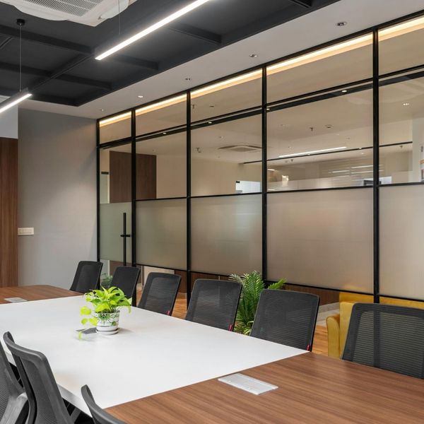 Professional commercial office renovation featuring a modern conference room with glass partition walls and industrial-style ceiling.