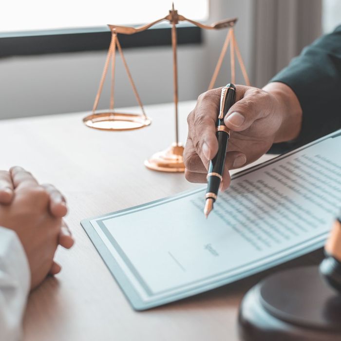 lawyer showing client something on piece of paper lawyer showing client something on piece of paper