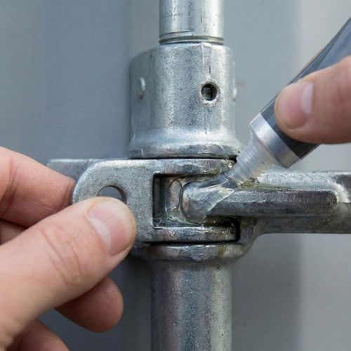 Lubricating the metal door hinges of a shipping container.