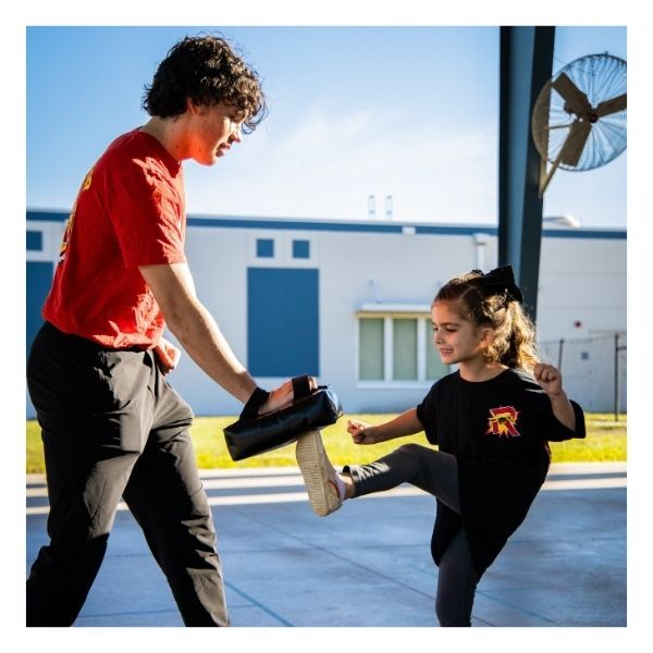 young girl practicing karate kick