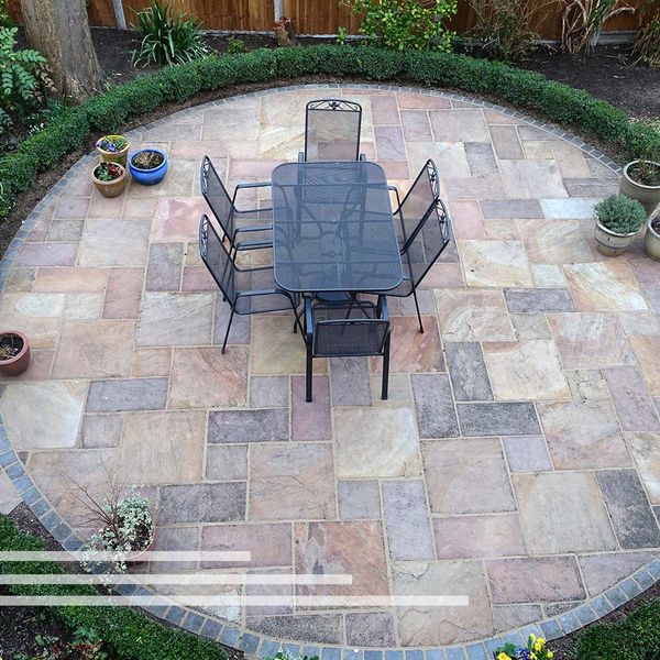 Circular patio with a table  and chairs on it.