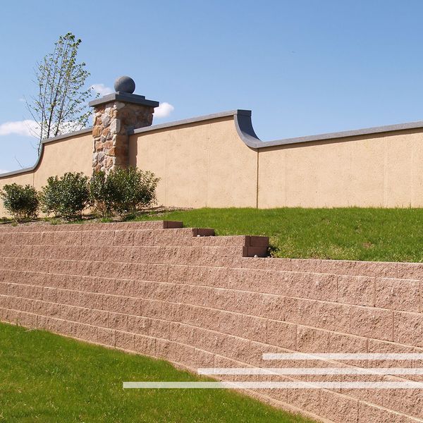 A brick retaining wall by a landscaped yard