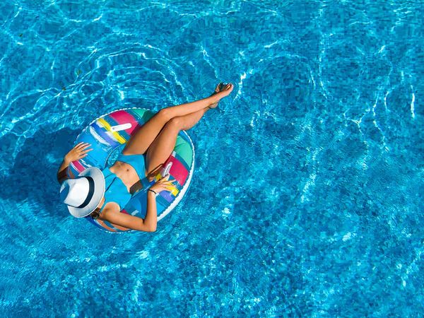 a person sitting in a pool float in a pool