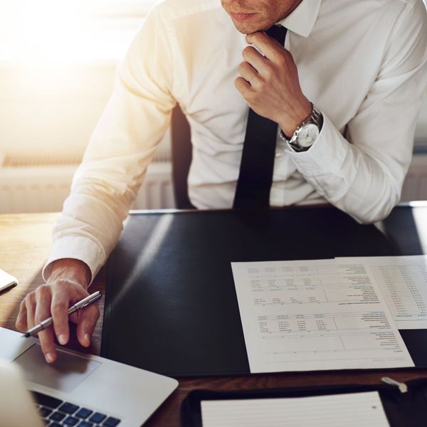 man on laptop with papers on desk