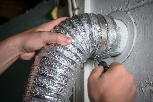 a hoop clamp being installed on a dryer vent connection
