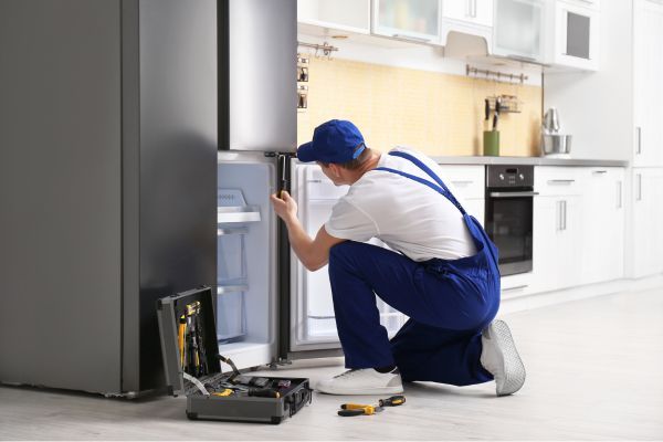 technician repairing refrigerator