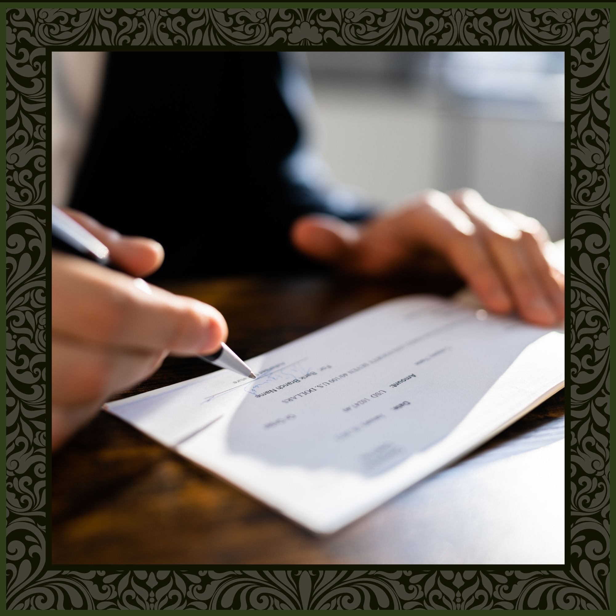 A close-up, shallow-focus shot of a person’s hands signing a professional business check with a silver pen on a wooden desk.