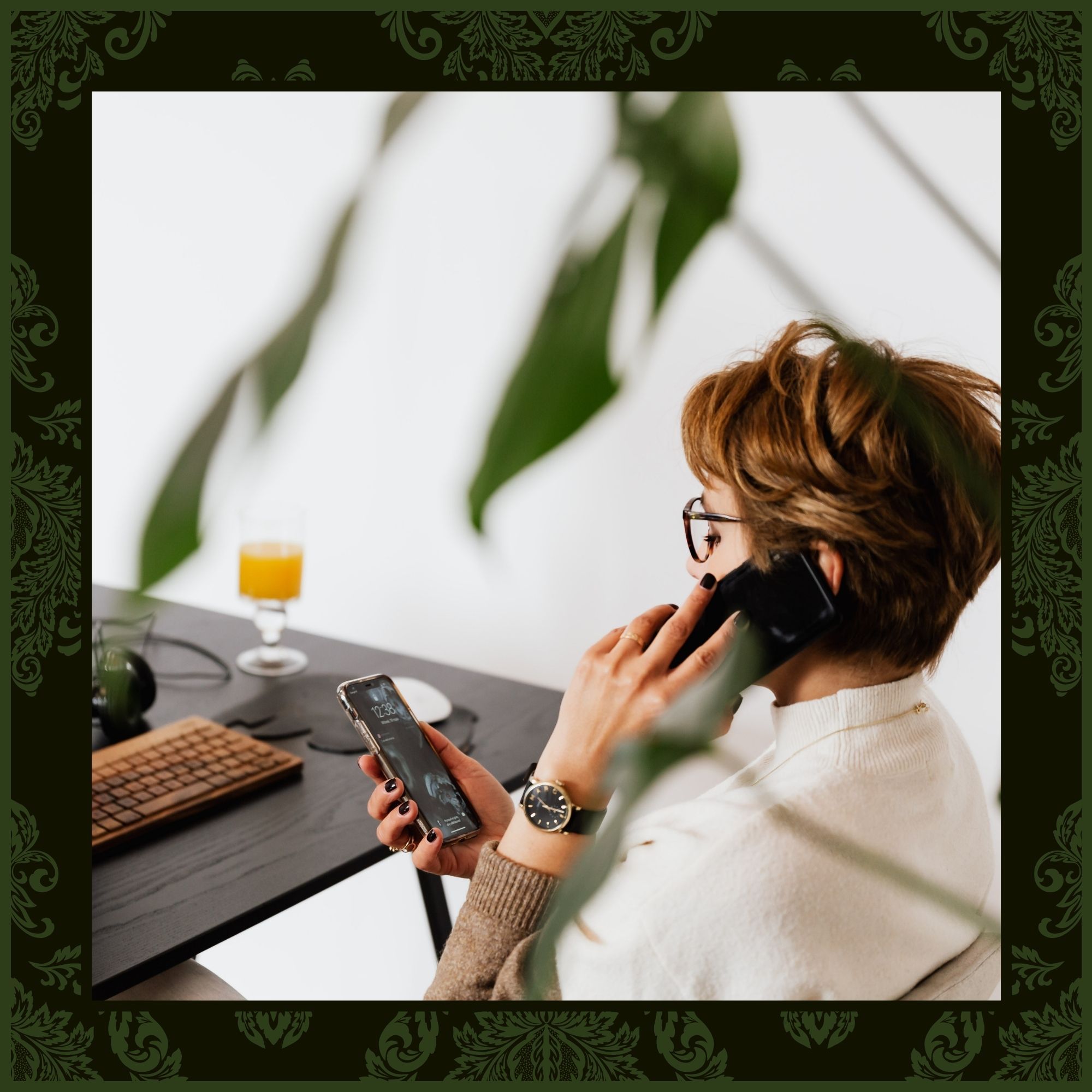 A woman in a professional setting talking on a cell phone while looking at a second smartphone, framed by a green botanical border.