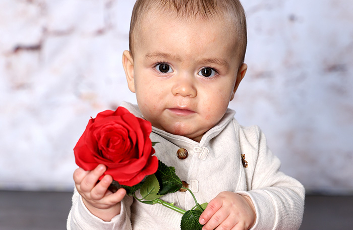 baby boy holding a rose