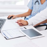 doctor with tablet and medical records
