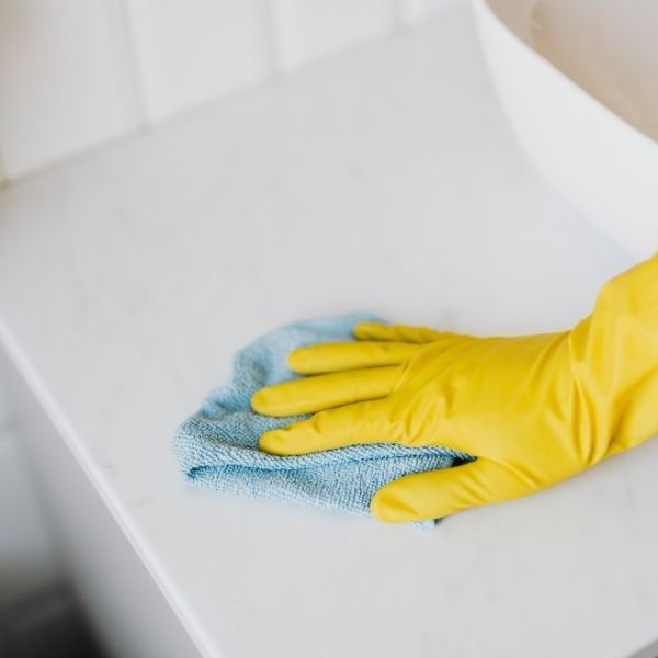 close up of gloved hand cleaning surface