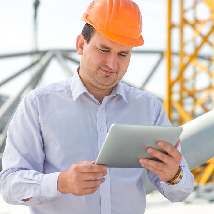 a construction worker looking at a tablet
