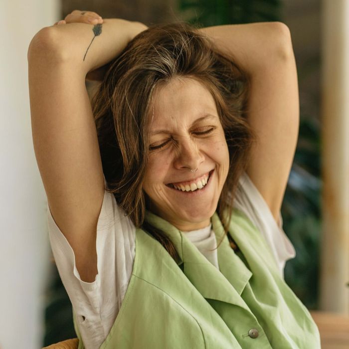 happy woman, arms above head, eyes closed in relief