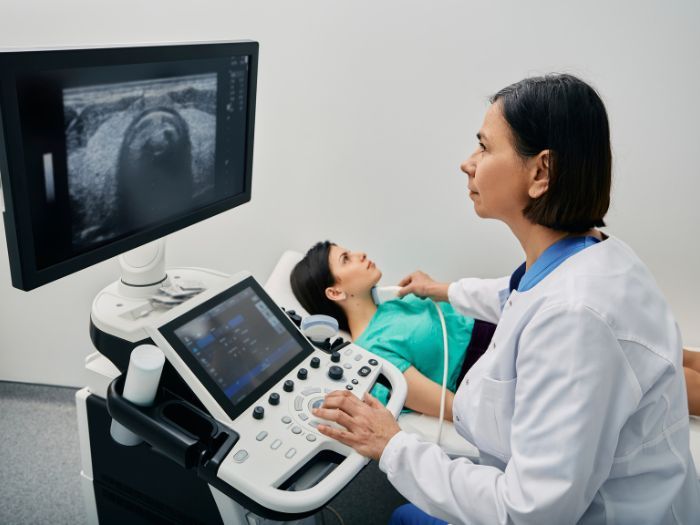 doctor performing vascular ultra sound on a patient's neck