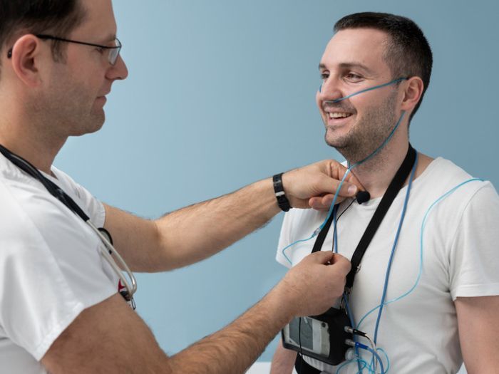 Doctor fitting a patient with monitoring devices for a sleep study