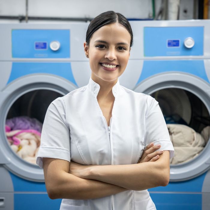 A professional cleaner in front of two washing machines