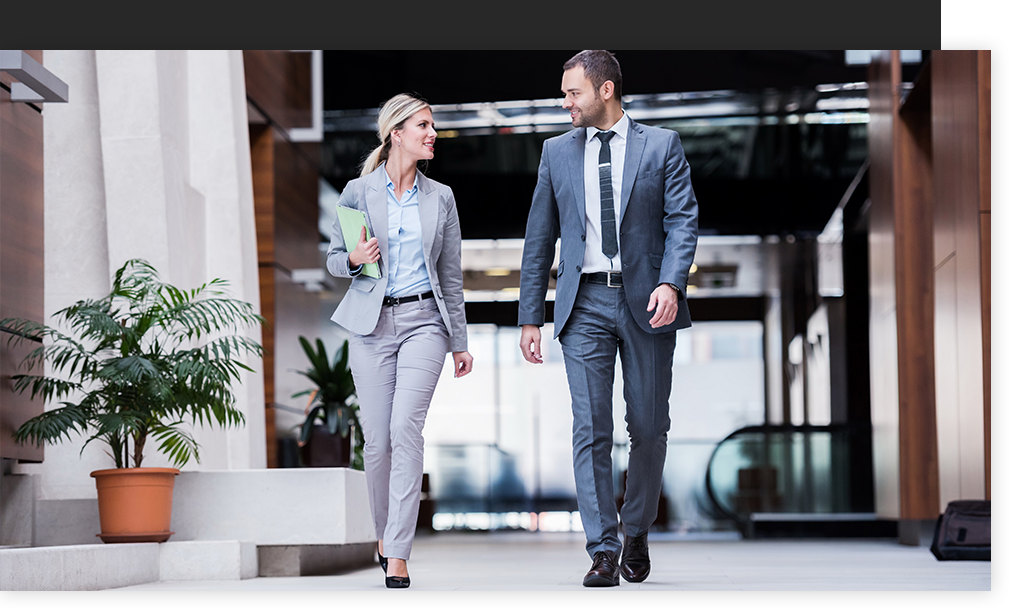 A businessman and businesswoman walking together 