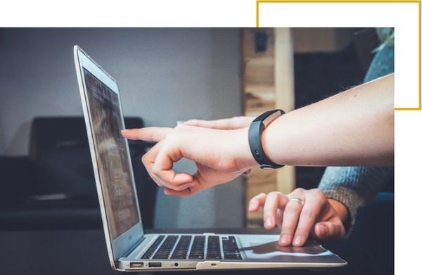 2 people pointing at a laptop screen