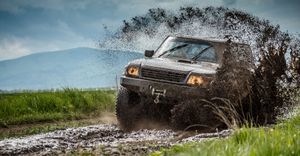 Car off-roading through mud. 