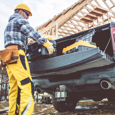 a man pulling toolboxes out of his work truck