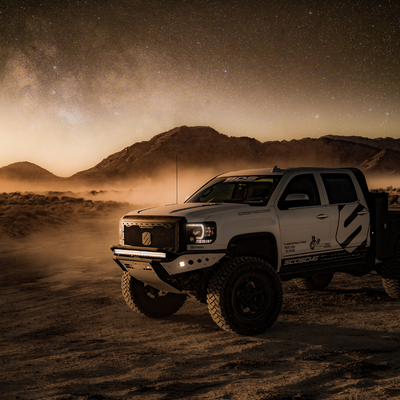 a truck in a desert with its lights on