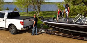 Truck with tonneau cover towing a boat