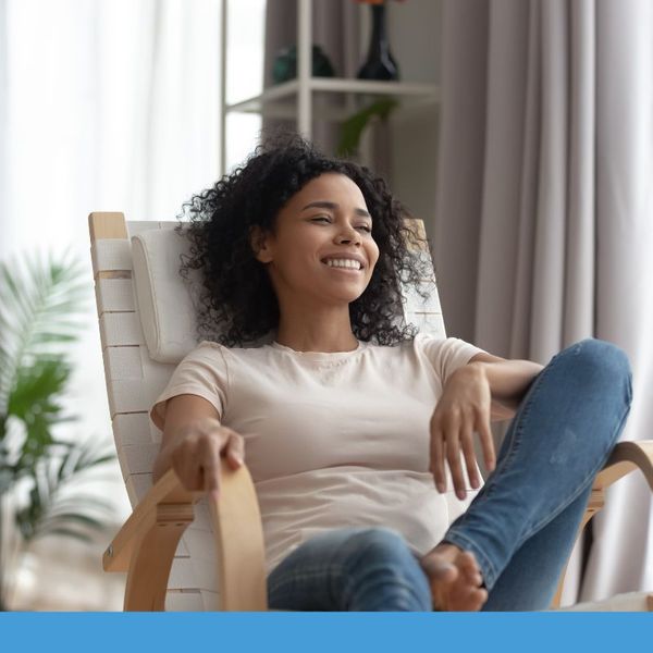 A woman relaxing in a chair indoors smiling