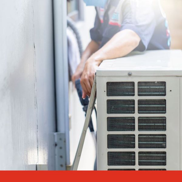 HVAC tech inspecting the back of an AC unit