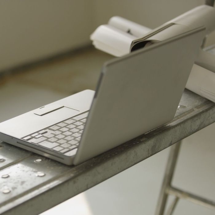 laptop on bench with rolls of paper