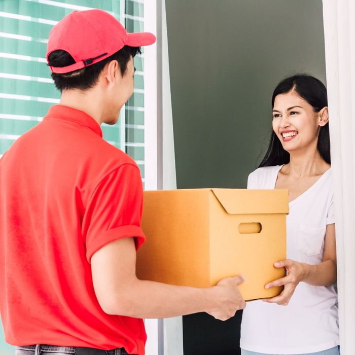Delivery man handing a woman a package. 