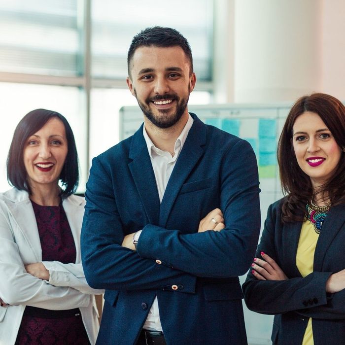 Three coworkers with their arms crossed 