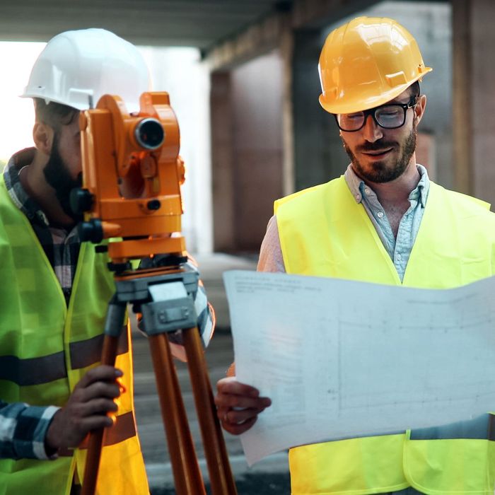 engineer and architect consulting blueprints on construction site