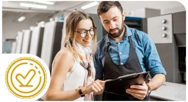 Woman and print operator looking at clipboard