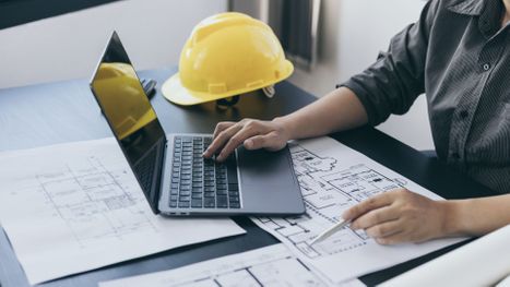 contractor with laptop and blueprints
