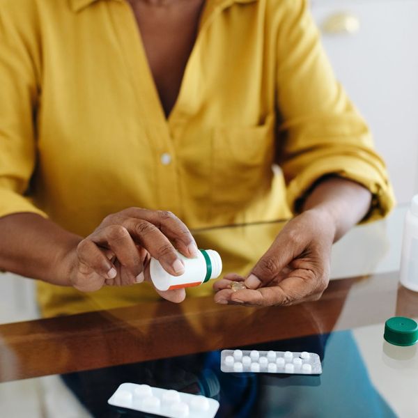 woman pouring medication into hand