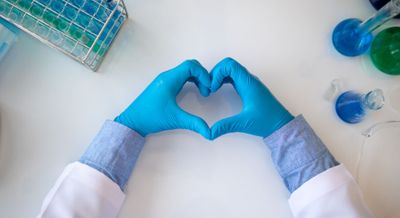 pharmacy technician making a heart with gloved hands