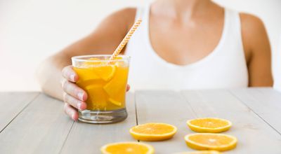 close-up-woman-holding-glass-orange-juice-with-drinking-straw-wooden-table (1).jpg