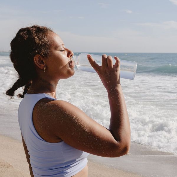 woman drinking water on a beach
