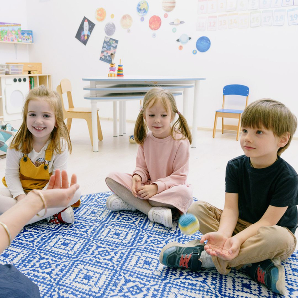 kids sitting with teacher in a circle