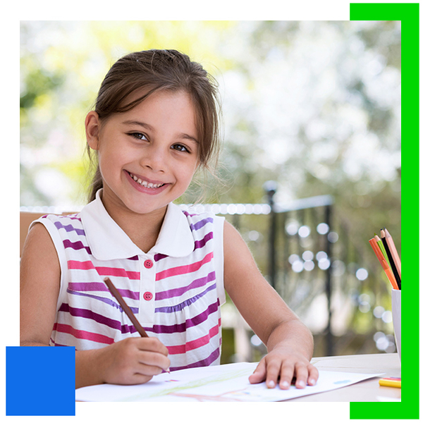 An image of a smiling preschool aged girl drawing